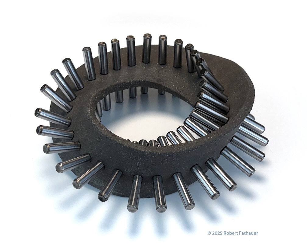 Ceramic sculpture of a Mobius band with metal dowels.